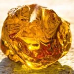 Pezzo di ambra baltica grezza illuminata dal sole, dai toni dorati e ambrati